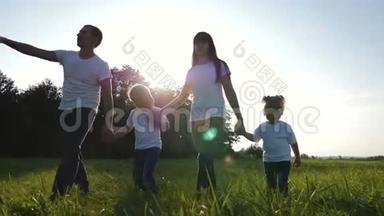 幸福的年轻一家人一起在新鲜空气中散步。 一对夫妇带着孩子在绿色公园里玩得很开心，享受着