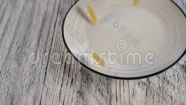 小麦面食落在白色盘子上，蓝色的边框落在木桌上
