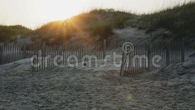 夏日的夕阳落在沙滩上的沙丘后面