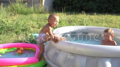 一个小男孩正在用水在充气游<strong>泳池里玩耍</strong>。 暑假和假期。