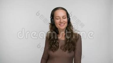 高兴的女人听着她最喜欢的一首关于智能手机跳舞和唱歌的歌，一边欣赏音乐的肖像。
