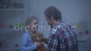 微笑的女孩带着泰迪熊拥抱父亲，回<strong>到家</strong>，雨天
