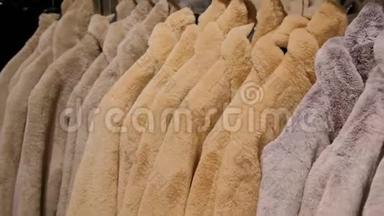 在一家零售时装店的衣架上出售的豪华人造毛皮冬季夹克。 快关门。