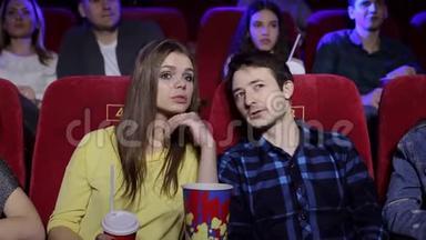 两个年轻人在电影院的肖像，他们交谈和看电影。
