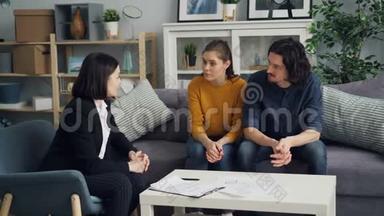 <strong>房地产商</strong>与购房者讨论房地产契约，夫妻双方在室内餐桌上