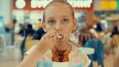 伤心的少年女孩在咖啡馆里吃巧克力冰淇淋。 十几岁的少女在吃冰淇淋甜点和华夫饼