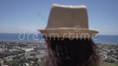 戴帽子的女人俯视城市和大海，仰视风景，旅行理念
