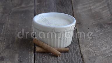 <strong>米饭布丁</strong>放在木制底座上的白色碗里。 将糖放入燃烧的过程。