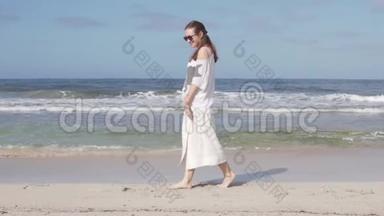一个快乐的女人正慢慢地走在海边的沙滩上