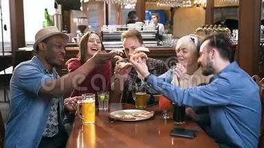 五个年轻时髦的朋友在时尚的酒吧和酒吧里拥抱着比萨饼。