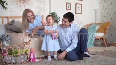 一家人在床上笑，爸爸妈妈在追女儿，女儿抱着娃娃。