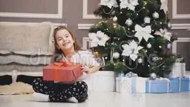 <strong>广告视频</strong>，小女孩得到了一个礼品盒，并呈现在相机前面的圣诞节背景。
