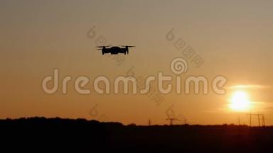 乡村夕阳西下，一架四翼飞机在天空中飞翔，在田野里无人驾驶