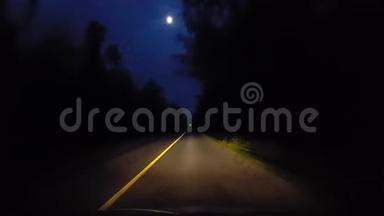 夜晚驾驶环绕森林树木的乡村后路。 晚上在乡村伍德兰道的司机视角