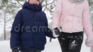 友好的全家人在降雪的情况下在冬天的森林里散步。 父亲、母亲、儿子和女儿