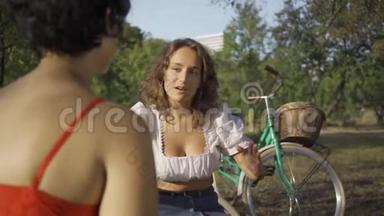 两个年轻的女人一边说话，一边坐在夏天的花园里，她们的自行车站在附近。 <strong>农<strong>村</strong>生活。 复<strong>古</strong>