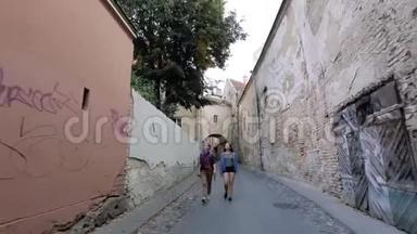 两个年轻的女人在维尔纽斯老城狭窄的街道上走来走去，谈笑风生。
