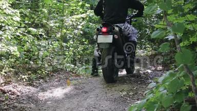 摩托车上穿着防护装备的运动员Enduro启动时，尘土和泥土从车轮下飞扬