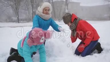 父母和孩子在<strong>雪</strong>地里<strong>玩</strong>耍。 妈妈和两个女儿在冬天堆<strong><strong>雪</strong>人</strong>。