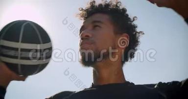 年轻自信的非裔美国男篮球运动员在户外向篮筐投掷球的特写镜头