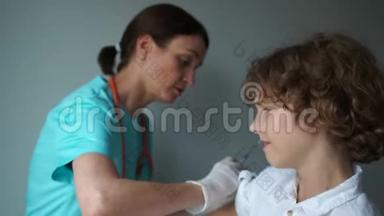 医生助理给一个卷毛男孩接种疫苗。 流感疫苗接种，免疫计划.. 医药和保健概念