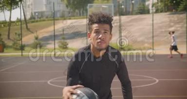 年轻英俊的非裔美国男篮球运动员在户外向篮筐投球的特写镜头