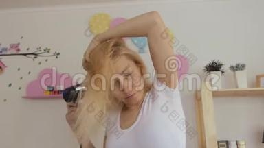 一个四十多岁的女人用吹风机擦干她<strong>染好</strong>的金发。