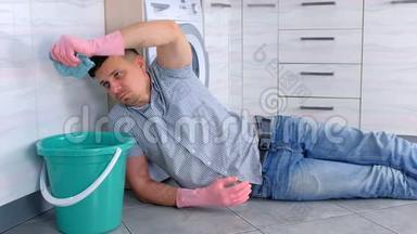 穿着橡胶手套的累人把抹布压在放在厨房地板上的水桶上。