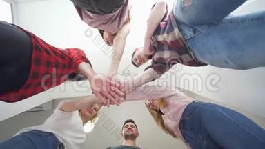 多元文化的朋友组合在一起叠起双手，底层看微笑的人