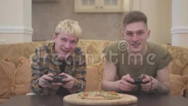 两个朋友坐在客厅的沙发上，热情地玩电子游戏，微笑着拿着操纵杆进来