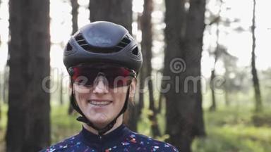 年轻迷人的骑自行车女人戴着黑色头盔和眼镜，微笑着的肖像。 单车概念