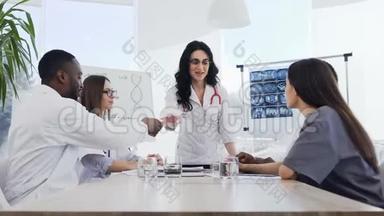 一位年轻的医务人员在医院的会议上做了有趣的讲座后，向女医生鼓掌。 医院