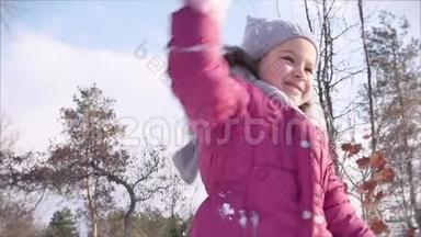 快乐，有趣的童年在阳光明媚的冬日户外。 女儿和父亲玩雪球，扔雪球