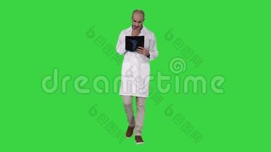 医生在绿色屏幕上行走时检查<strong>肺部</strong>X线片，Chroma键。