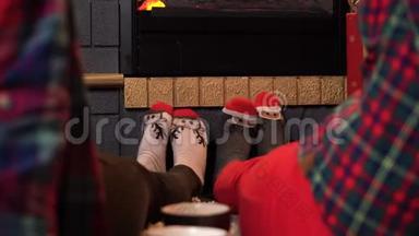 两个女孩坐在壁炉旁，穿着袜子，像一只鹿。 舒适的壁炉旁有几英尺的袜子
