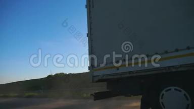 卡车与货物拖车骑在道路和运输货物在日落时间。 卡车在乡间<strong>穿梭</strong>