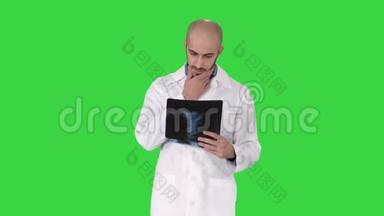 医生在绿色屏幕上行走时检查肺部X线片，Chroma键。