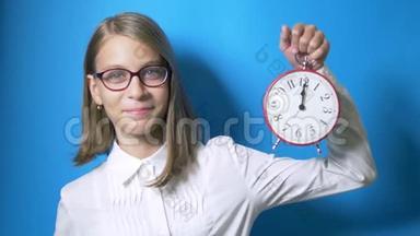 <strong>学习</strong>时间观念，回学校.. 一个戴着眼镜的聪明的女学生拿着一个大钟，<strong>展示</strong>了一个超级标志。