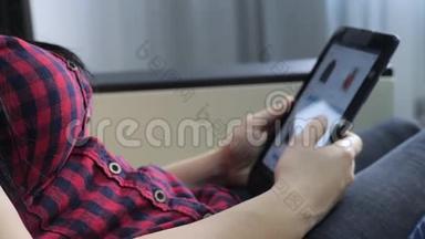 网上购物的概念。 年轻女孩坐在网上商店里看商品的生活方式，用数字购物