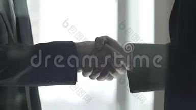 商务伙伴在洽谈室握手，成交手势