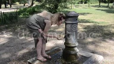 在意大利罗马的<strong>一条街</strong>道上，<strong>一</strong>个年轻的女孩在炎热的夏天从罗马鼻子的饮水机里喝水