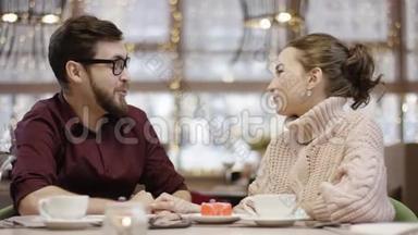 成年男子和妻子坐在餐馆的餐桌旁，男人打电话给服务员，服务员送花给他们，男人送花