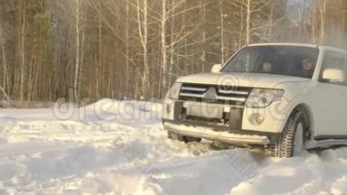 suv汽车在雪地里行驶在雪地里的冬季道路上，在雪地里的森林背景下慢动作