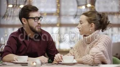 当服务员给他们端生寿司的时候，年轻的男人和女人正在一桌一桌餐厅里交谈