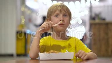 一个小男孩在街头咖啡馆吃美味的华夫饼的特写镜头。 街头食品概念