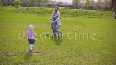 长胡子的父亲和两个女儿在体育场踢足球。 <strong>夏日</strong>，<strong>绿草</strong>如茵..