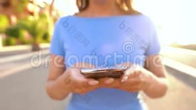日落时分，女人在棕榈街散步时使用智能手机