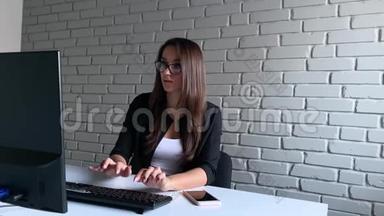 女商人<strong>坐在</strong>办公桌<strong>前</strong>，用她的笔记本<strong>电脑</strong>，在办公室环境中表达成功