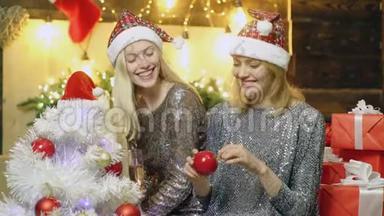 新年里微笑的女孩`帽子喝香槟，<strong>装饰圣诞树</strong>。 女孩们<strong>装饰圣诞树</strong>。 新