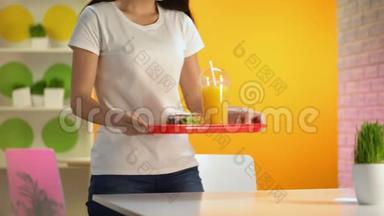 快乐<strong>的</strong>女人把托盘和沙拉和新鲜橙汁放在桌子上，<strong>小吃店</strong>